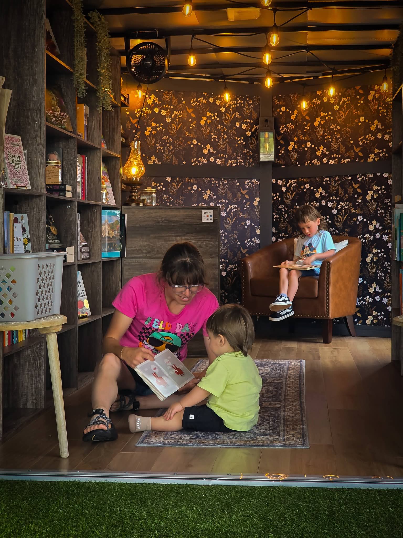 A family reading books together inside The Ledger & Lamp mobile bookstore in Florida